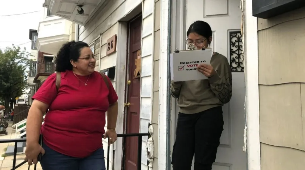 Young woman seen registering to vote at the door of her home