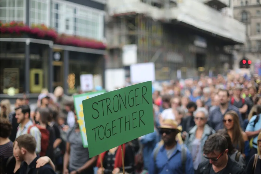 A sign held by a demonstrator reading "Stronger Together"