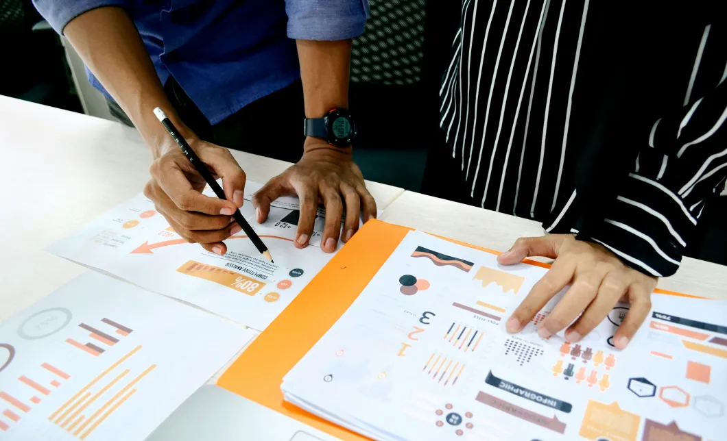 Photo of two people huddled over data on their desk