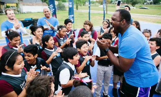 Young athletes huddling on the basketball court with their coach